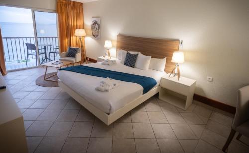 a hotel room with a large bed and a balcony at Hotel Arawak Beach Resort in Le Gosier