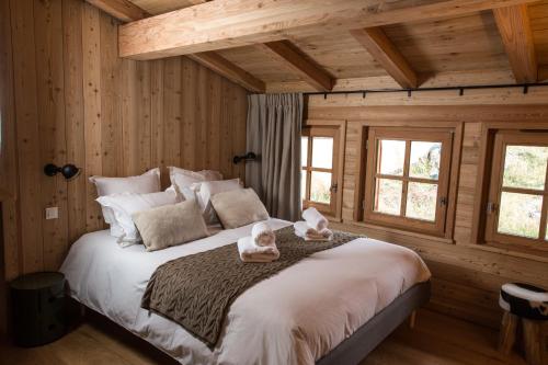 une chambre avec un grand lit avec deux animaux en peluche dessus dans l'établissement Notre Horizon, à Villard-Reculas