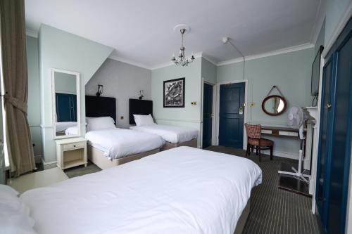 a hotel room with two beds and a chair at White Hart, Newmarket by Marston's Inns in Newmarket