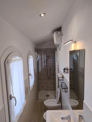 ピエトラサンタにあるCasa Nildoのトイレとシャワー付きの白いバスルーム