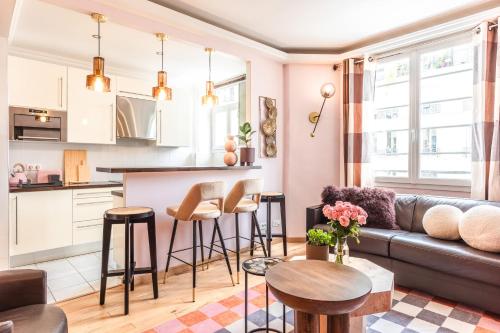 un salon et une cuisine avec un canapé et une table dans l'établissement Cosy & Design apartment 4 guests - Eiffel Tower, à Paris