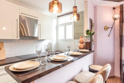 une cuisine avec une table avec des assiettes et des verres à vin dans l'établissement Cosy & Design apartment 4 guests - Eiffel Tower, à Paris