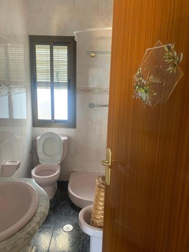 a bathroom with a toilet and a sink at La Cuesta House in Castell de Ferro