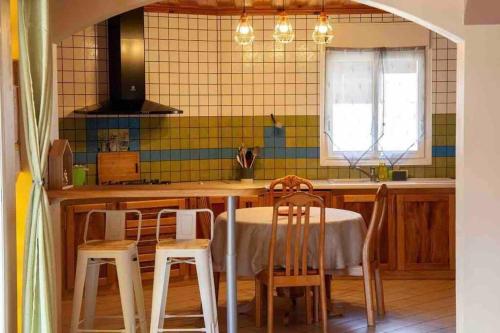 a kitchen with a table and two chairs and a counter at Villa Passiflora in Cilaos