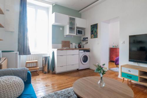 un salon avec un vase de fleurs sur une table dans l'établissement Appartement rénové cœur de ville Les Sables - 4 personnes, à Les Sables-dʼOlonne