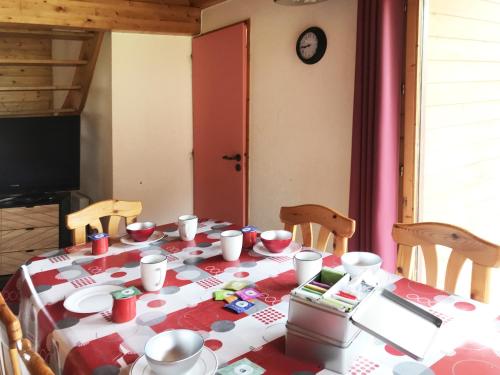 une table avec un chiffon de table rouge et blanc dans l'établissement Chalet nordique 31, à La Féclaz