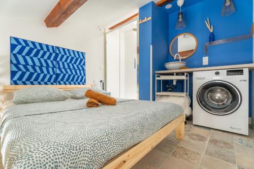 - une chambre bleue avec un lit et un lave-linge dans l'établissement Athènes olympe Bleu, à Marseille