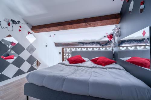une chambre avec un grand lit avec des oreillers rouges dans l'établissement Le Poker Love Jacuzzi, à Marseille