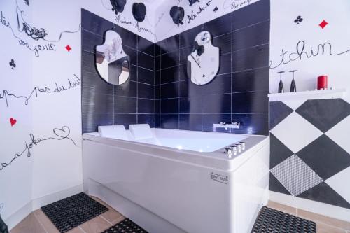 La salle de bains est pourvue de carrelage noir et blanc et d'un lavabo. dans l'établissement Le Poker Love Jacuzzi, à Marseille