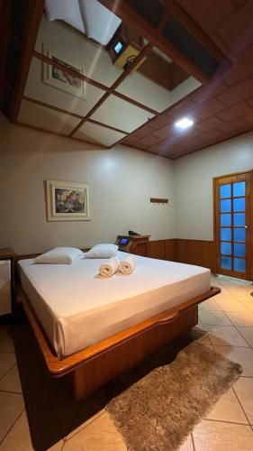 a bedroom with a large bed with two towels on it at Status Motel Ourinhos in Ourinhos