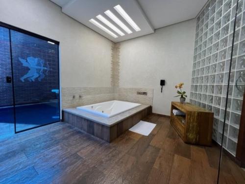 a large bathroom with a tub and a shower at Status Motel Ourinhos in Ourinhos