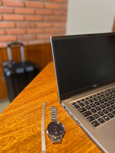 a watch sitting on a table next to a laptop computer at Status Motel Ourinhos in Ourinhos