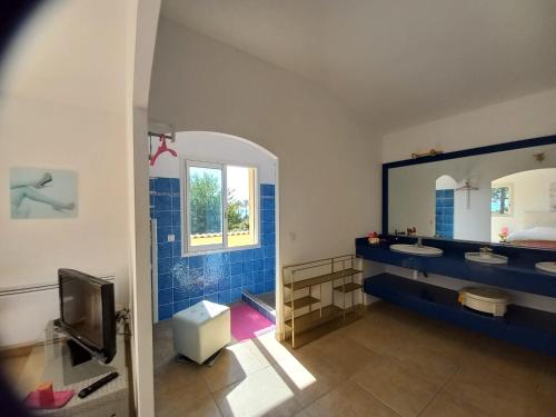 une salle de bain avec deux lavabos et un grand miroir dans l'établissement PIANICCIA-villa standing- pieds dans l'eau-piscine privée, à Sari-Solenzara