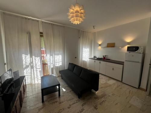 a living room with a couch and a kitchen at Home & Beach Il Duca in Lido di Ostia
