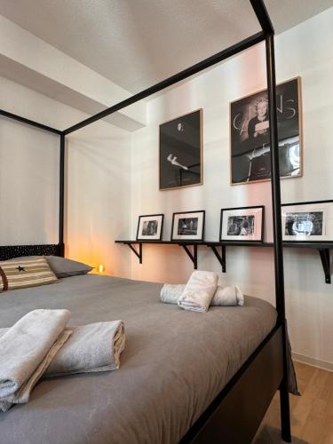 - une chambre avec 2 lits et des photos sur le mur dans l'établissement Le 7ème Art, Hyper centre, à Mulhouse