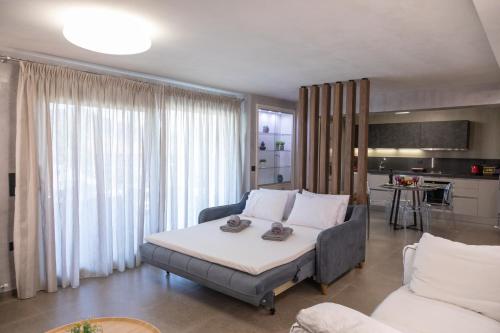 una sala de estar con una cama y un sofá en ILIOS Luxury Apartment, en Nea Iraklitsa
