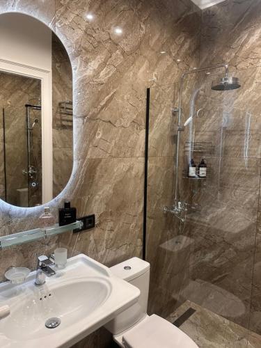 a bathroom with a toilet and a sink and a shower at Easy Rest in Tbilisi City