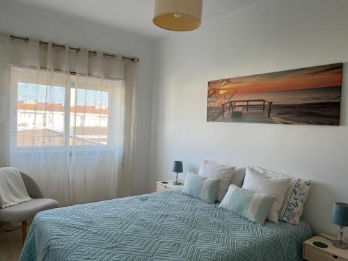 a bedroom with a bed with a painting on the wall at Confort Apartment 2 Bedrooms in Alhos Vedros