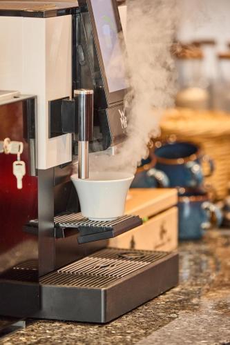 a coffee maker with a mixing bowl on a counter at Hotel Hornstein in Nonnenhorn