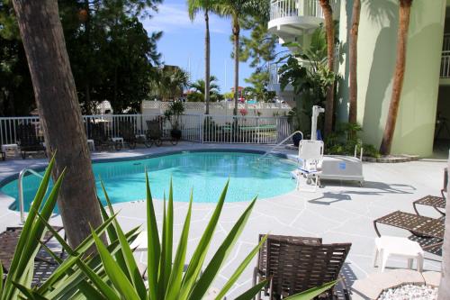 a beach with a pool, chairs, and a pool table at Chart House Suites on Clearwater Bay in Clearwater Beach