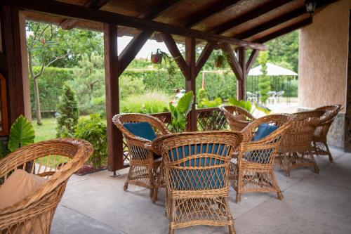 a group of wicker chairs and tables on a patio at Guesthouse Kristina in Palić