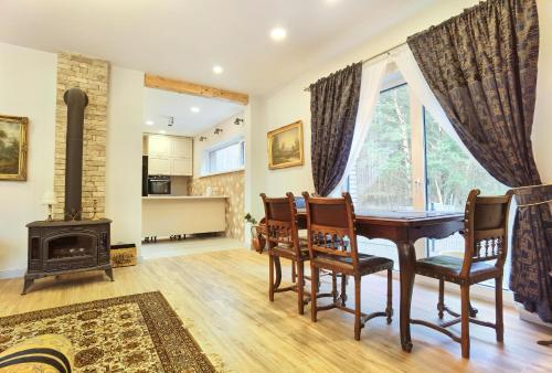 a dining room with a table and a wood stove at Vila Omama in Palanga