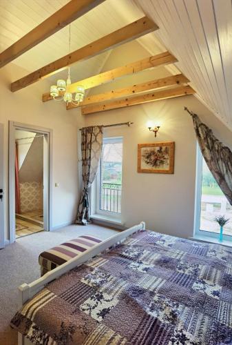 a bedroom with a large bed and a wooden ceiling at Vila Omama in Palanga
