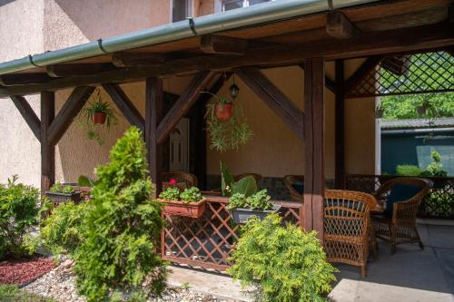 a wooden pergola on a house with plants at Guesthouse Kristina in Palić