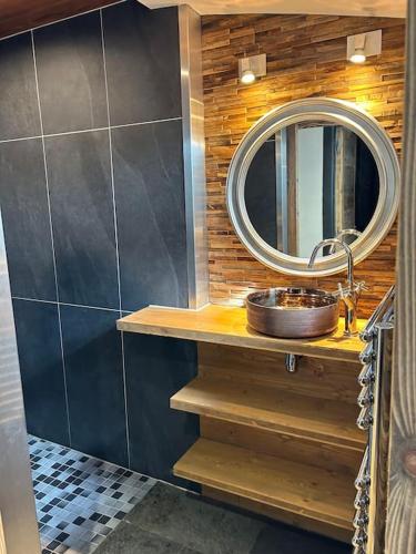 une salle de bain avec un lavabo et un miroir dans l'établissement La maison Swan, à Gérardmer