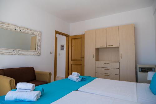 a bedroom with two beds with towels on them at Elounda Residence Resort & Waterpark in Elounda