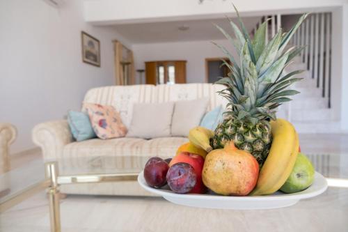 a plate of fruit on a table in a living room at Elounda Residence Resort & Waterpark in Elounda