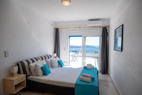 a bedroom with a bed with a view of the ocean at Elounda Residence Resort & Waterpark in Elounda