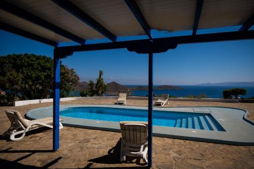 a swimming pool with two chairs and a umbrella at Elounda Residence Resort & Waterpark in Elounda