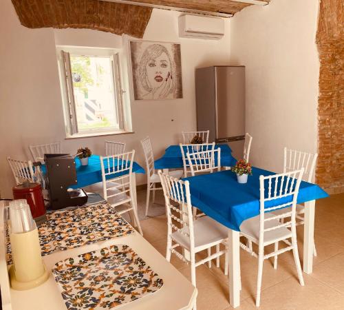a dining room with blue tables and white chairs at Al Mare Fuori in Calopezzati