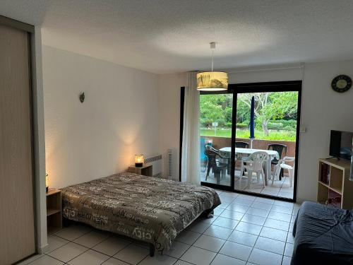 ein Schlafzimmer mit einem Bett und ein Balkon mit einem Tisch in der Unterkunft Les Marines in San-Nicolao