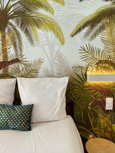 - une chambre avec un lit orné d'une fresque murale de palmiers dans l'établissement 
