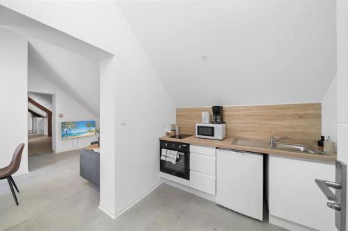 une cuisine avec un évier et un plan de travail dans l'établissement L'appartement des Grands Crus, à Marey-lès-Fussey