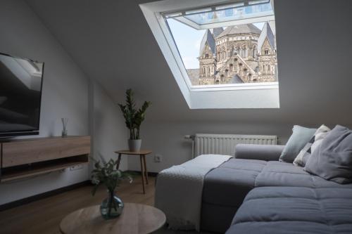 un salon avec un canapé et une grande fenêtre dans l'établissement Über den Dächern von Koblenz, à Coblence
