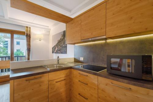 a kitchen with wooden cabinets and a microwave at Kriendl Nr 2 in Valdaora