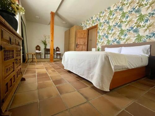 a bedroom with a bed and a tiled floor at Quinta Mazagatos Segovia in La Lastrilla