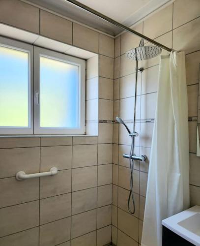 une salle de bain avec une douche avec un rideau de douche dans l'établissement Maison familiale sur le port, à Lézardrieux