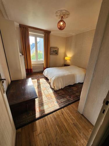 une chambre avec un lit et une grande fenêtre dans l'établissement Maison familiale sur le port, à Lézardrieux