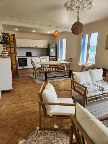 un salon avec une table et des chaises et une cuisine dans l'établissement Maison familiale sur le port, à Lézardrieux