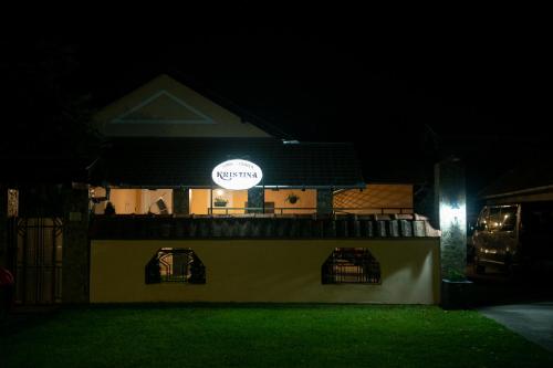 a building with a sign on it at night at Guesthouse Kristina in Palić