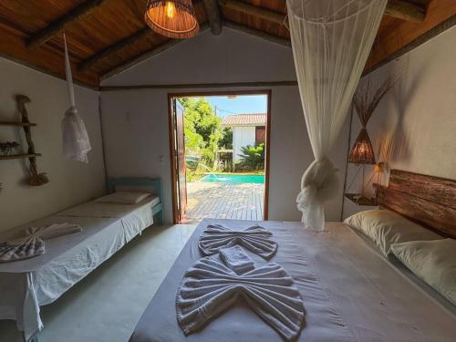 a bedroom with two beds and a door to a yard at Villa Atlântic Icaraizinho 700 m da praia in Icaraí