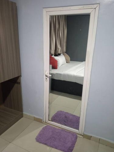a door with a mirror in a room with a bed at Morada Hotels Ltd in Lagos