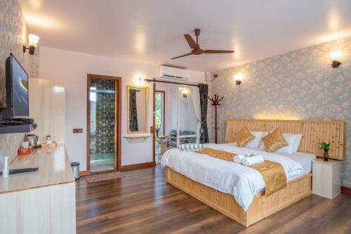 a bedroom with a large bed and a tv at Ostrov Palm in Ukulhas