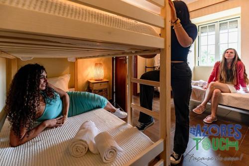 two girls are standing in a bunk bed at Casa da Avó Natal in Lajes