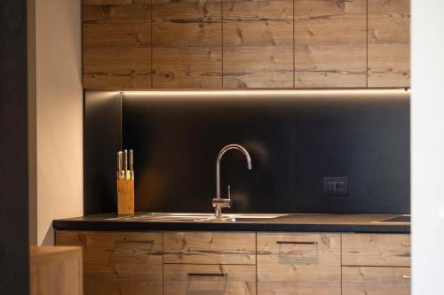 a kitchen with a sink and wooden cabinets at Villa Kriendl Nr 1 Lanzwiese in Valdaora
