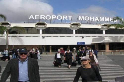 a group of people walking in front of a airport at Adorable Apartamento a 8 Min del Aeropuerto de Casablanca,WiFi Ultra Rapido y Parking Gratis in Derroua